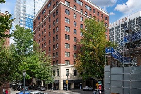 a tall red brick building on the corner of a city street